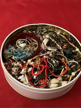 Assorted costume jewelry in a tin box